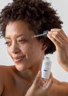 lifestyle photo of woman putting tizo vitamin c & e serum on her face